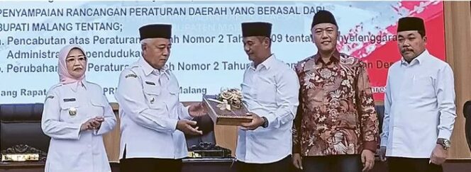 
					<em>Bupati Malang H. M Sanusi bersama Ketua DPRD Kabupaten Malang Darmadi saat serah terima dokumen rancangan perubahan Perda tentang Penetapan Desa di rapat paripurna. (Image courtesy: RADAR KANJURUHAN)</em>