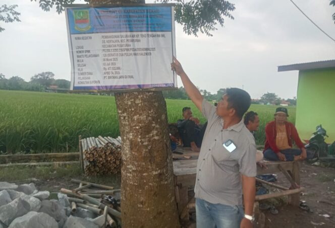 
					<em>Papan proyek pembangunan saluran air di Desa Kertajaya yang tertera lokasinya berbeda dengan lokasi pembangunan sebenarnya di lapangan.</em>
