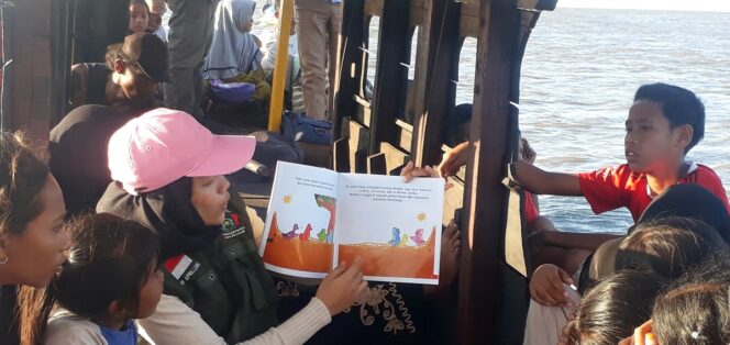 
					Seorang relawan Rumah Edukasi Anak Pesisir (Redaksi), Atika Hasibuan, antusias menunjukkan buku cerita kepada para siswa saat sesi belajar unik di atas perahu, menumbuhkan kecintaan membaca dengan suasana baru.