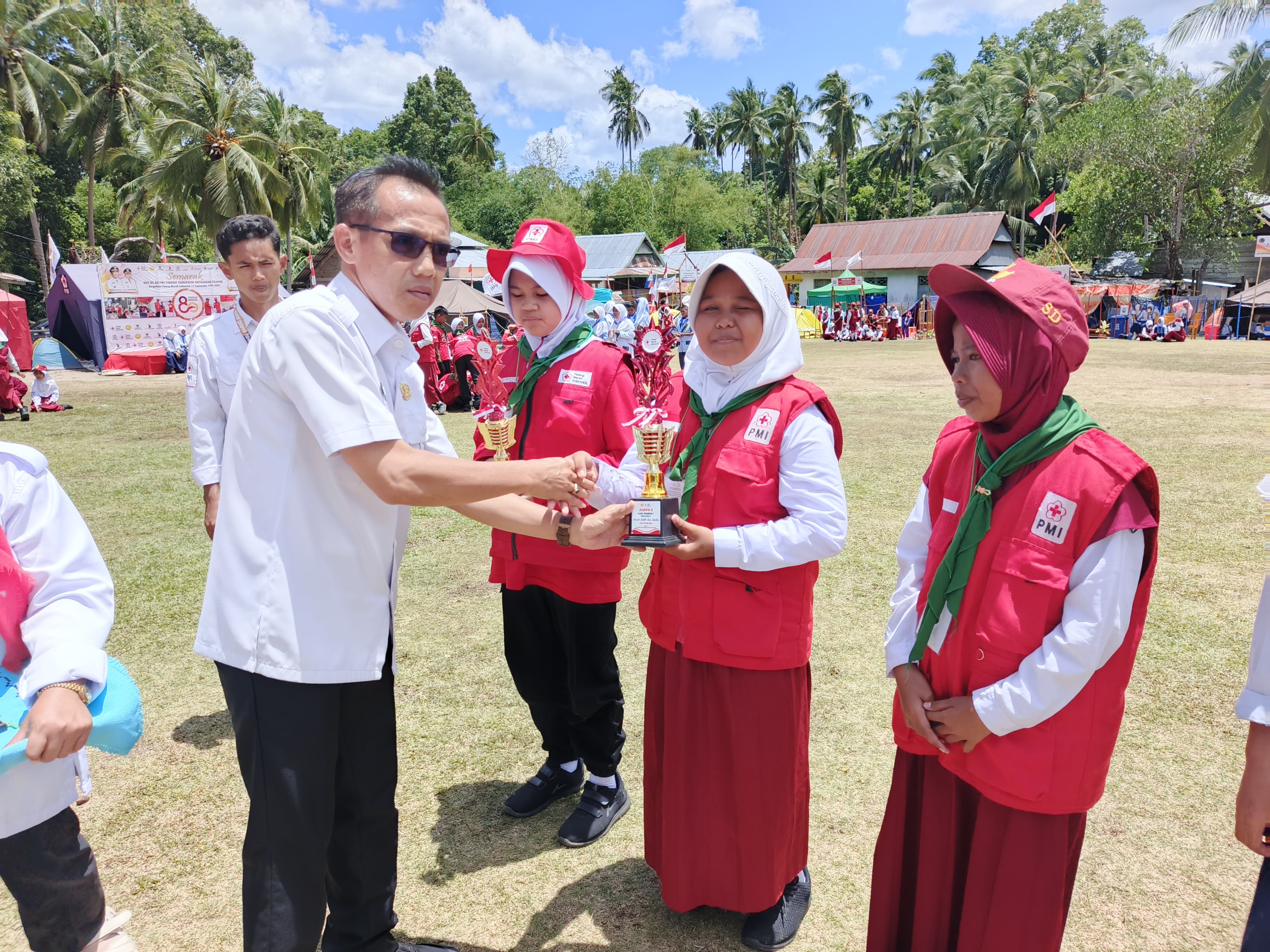 Siswi PMR SDI Bonerate menerima piala langsung dari pejabat dalam Perkemahan HUT PMI ke-80 Kabupaten Selayar.